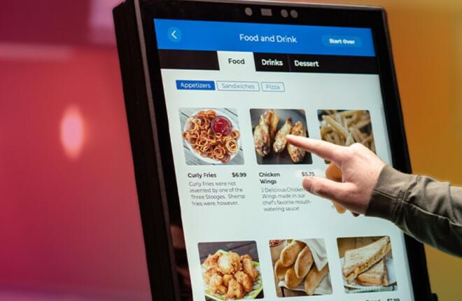 Sync Service kiosk showing appetizers; finger pointing at chicken wings option.