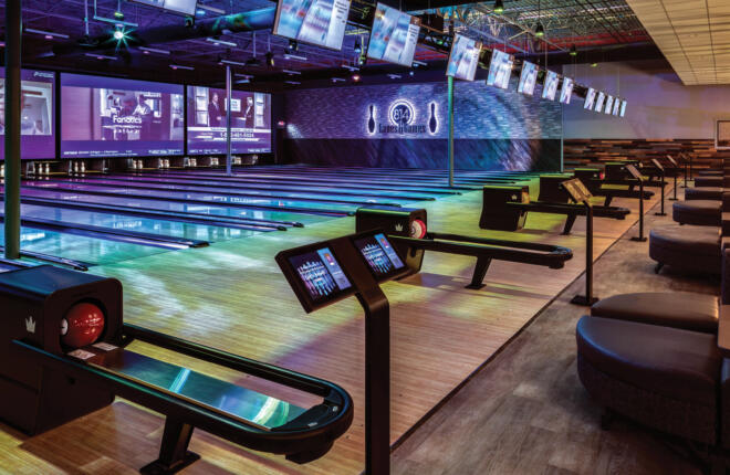 colorful bowling lanes with tvs and projector screens at end of lanes