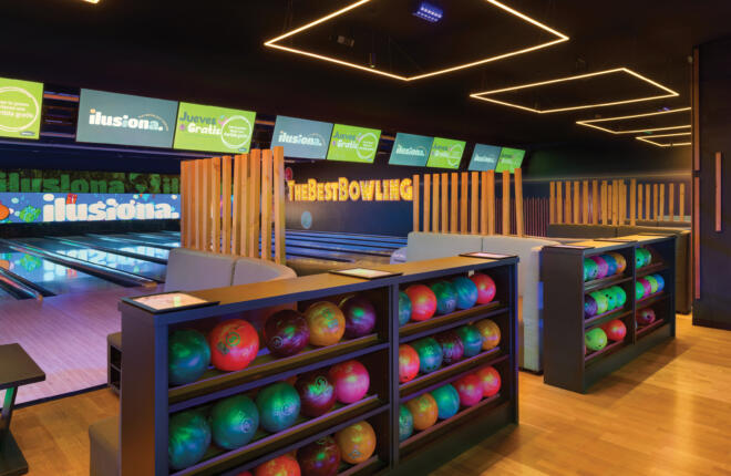 Colorful bowling alley with vibrant bowling balls and "Ilusiona" branding