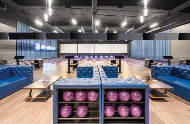bowlers area looking down lane with seating and bowling ball rack