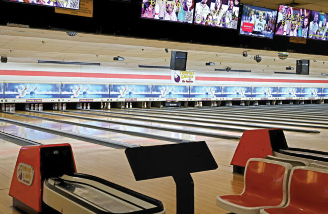 Tenpins & More branded bowling lanes in Rio Rancho, NM, featuring overhead scoring monitors and classic red bowler seating.