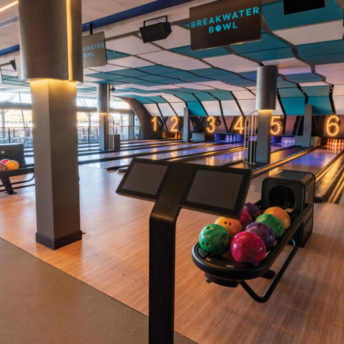 Breakwater Bowl lanes with colorful balls and digital scoring screens.