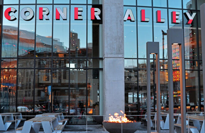 Patio seating, tall glass exterior windows with The Corner Alley logo word mark