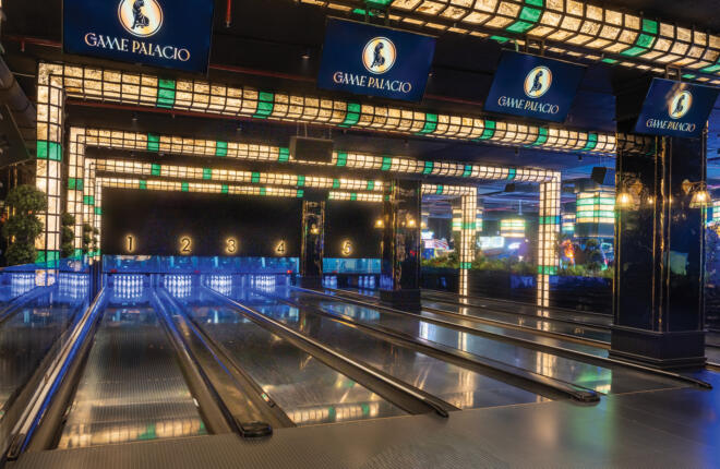 Luxury bowling lanes at Game Palacio with dramatic lighting, digital scoring displays, and a high-end entertainment atmosphere.