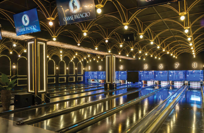 Luxurious bowling alley with ornate ceiling, screens, and lanes numbered 1 to 8.