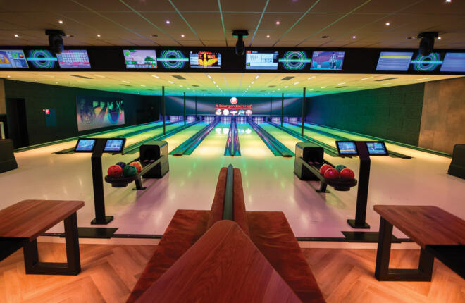 Wide angle from behind Brunswick bowling lanes, sync scoring and seating area