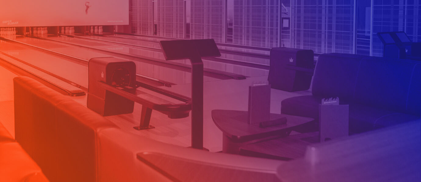 Brunswick Sync scoring consoles and lane-side seating at a modern bowling venue, overlaid with a red-to-blue gradient, used as a header image for the Brunswick Sponsor Pavilion at Bowl Expo 2026.